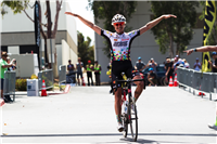 Elite road cyclist Joshua Berry (Jelly Belly p/b Maxxis) crossing the line first, ahead of a stacked field of fellow professional racers and amateur competitors