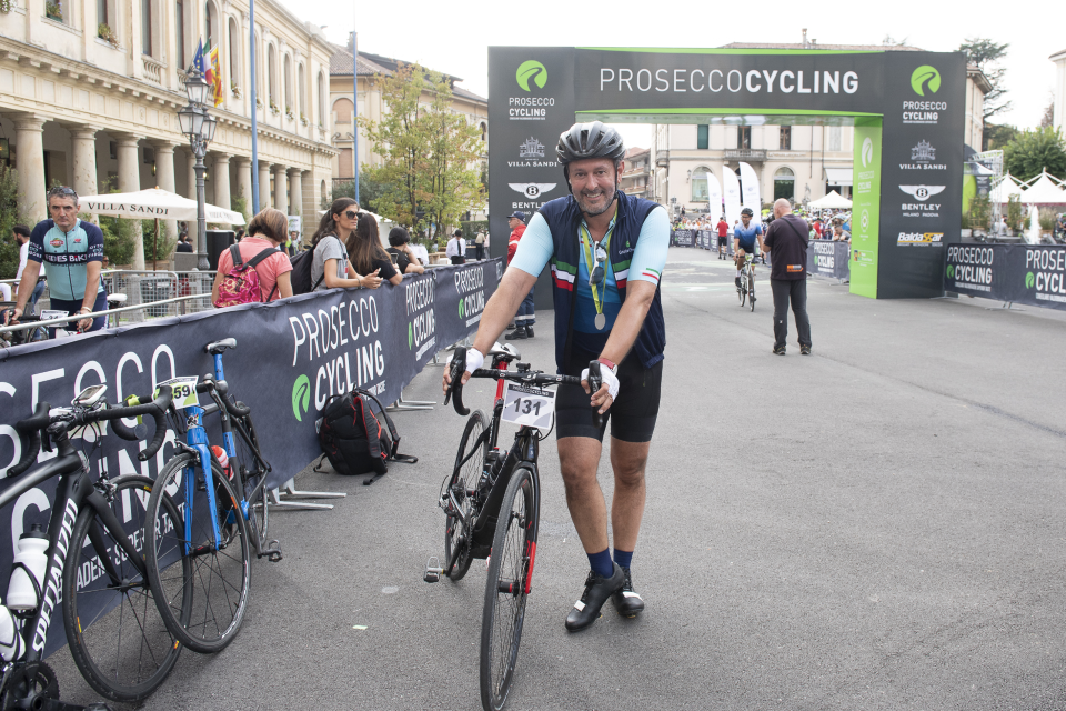 All smiles as Terence Mauri crosses the line to complete Prosecco Cycling, a battle against the hills and the gourmet food stops!