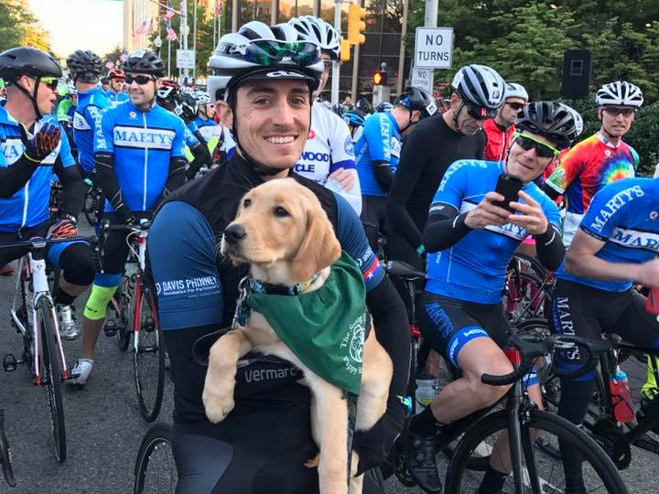 rider holding one of the many guide dogs who benefit from the ride from the charity, The Seeing Eye.
