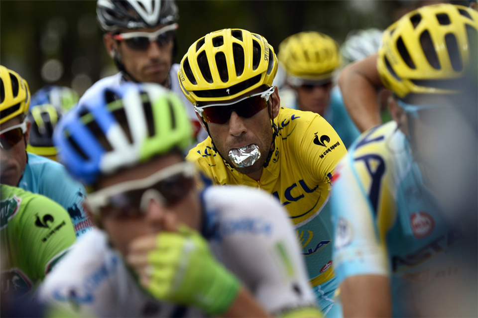 Vincenzo Nibali holds a snack in his mouth, saving it for later